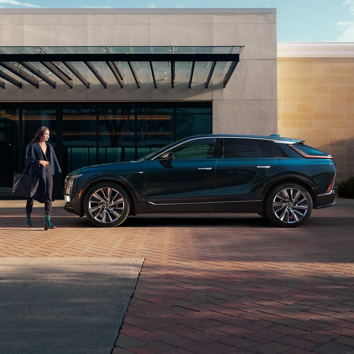 Side view of the 2027 Cadillac LYRIQ parked outside a modern building.