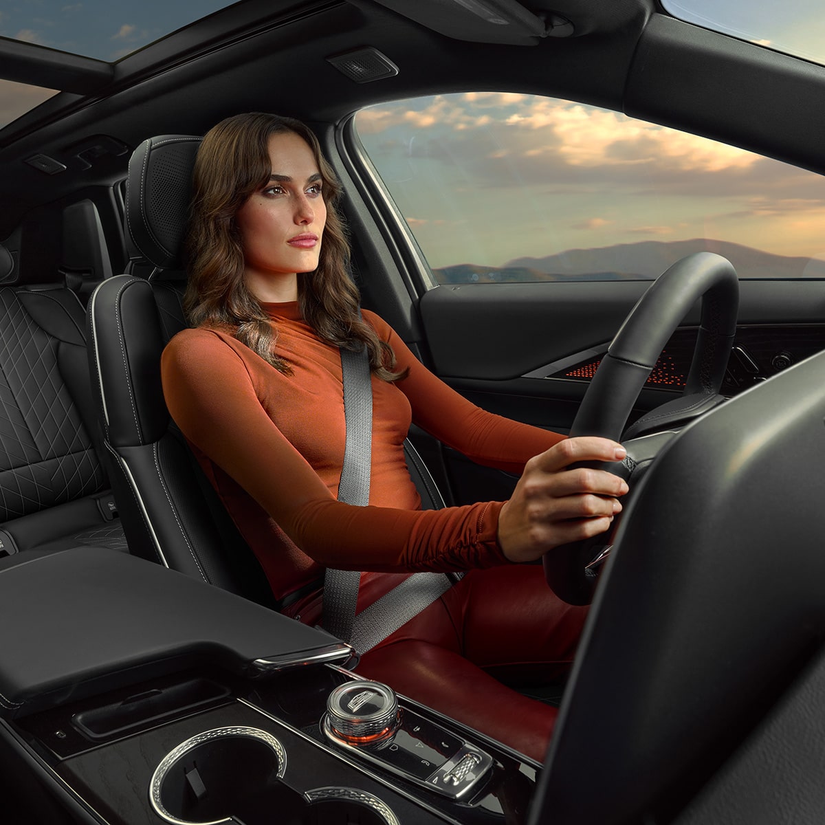 A person seated at the driver's seat of the 2027 Cadillac LYRIQ.