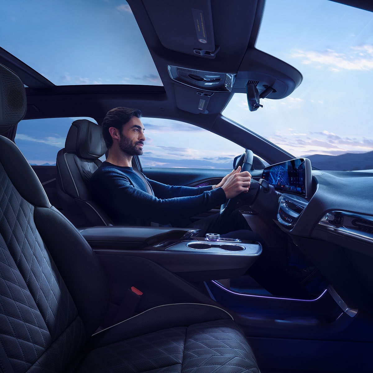 Front passenger's view of the interiors of the 2027 Cadillac LYRIQ with a person seated at the driver's seat.