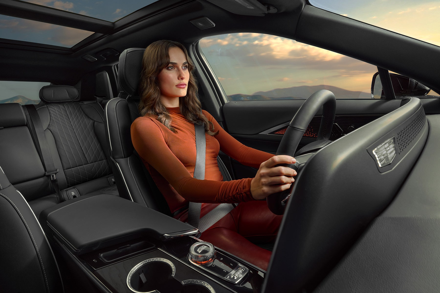 A person seated at the driver's seat of the 2027 Cadillac LYRIQ.
