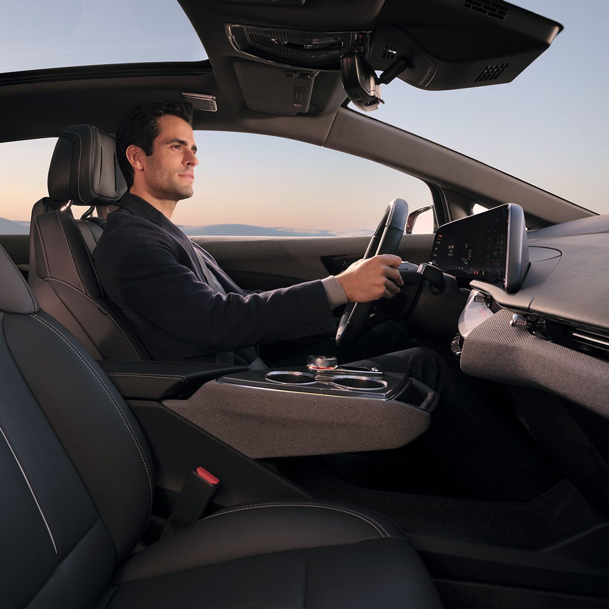 Vue passager d’un homme conduisant une Cadillac OPTIQ 2027.