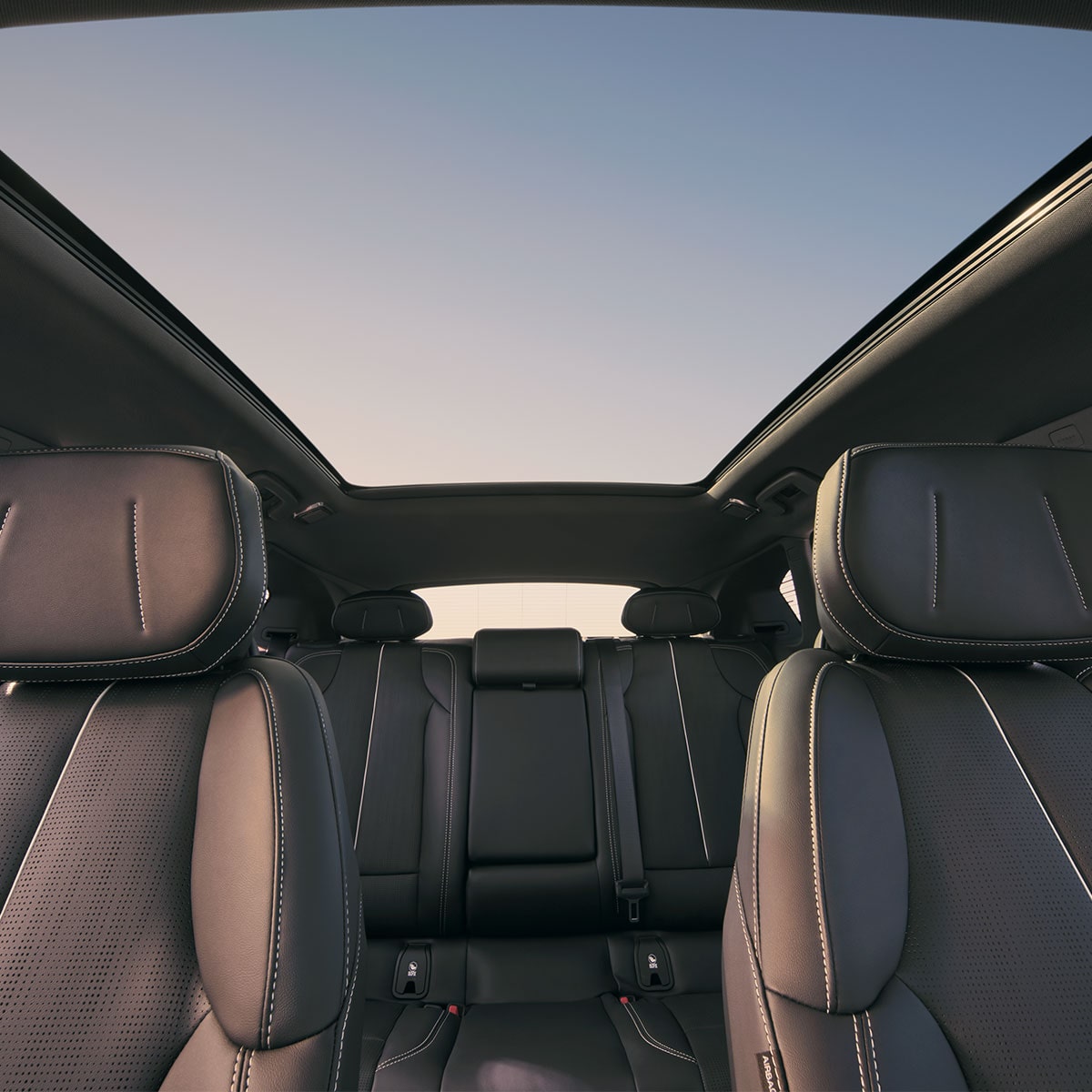 Vue du tableau de bord des deux rangées de sièges de la Cadillac OPTIQ et du toit skyglass.