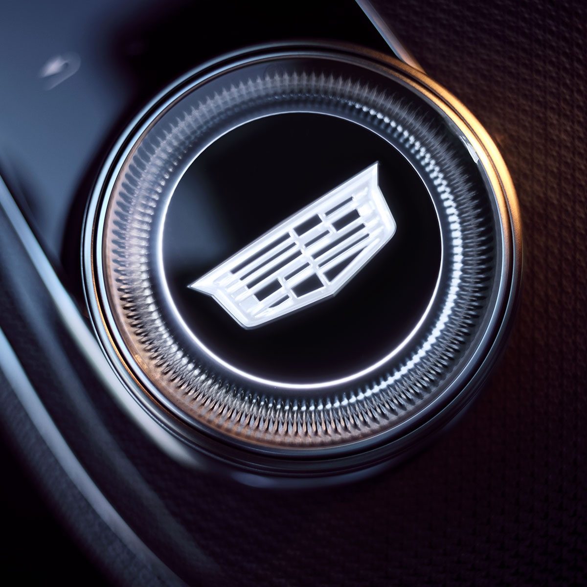 Gros plan du bouton de vitesse OPTIQ 2027 de la Cadillac avec un logo Cadillac au centre.