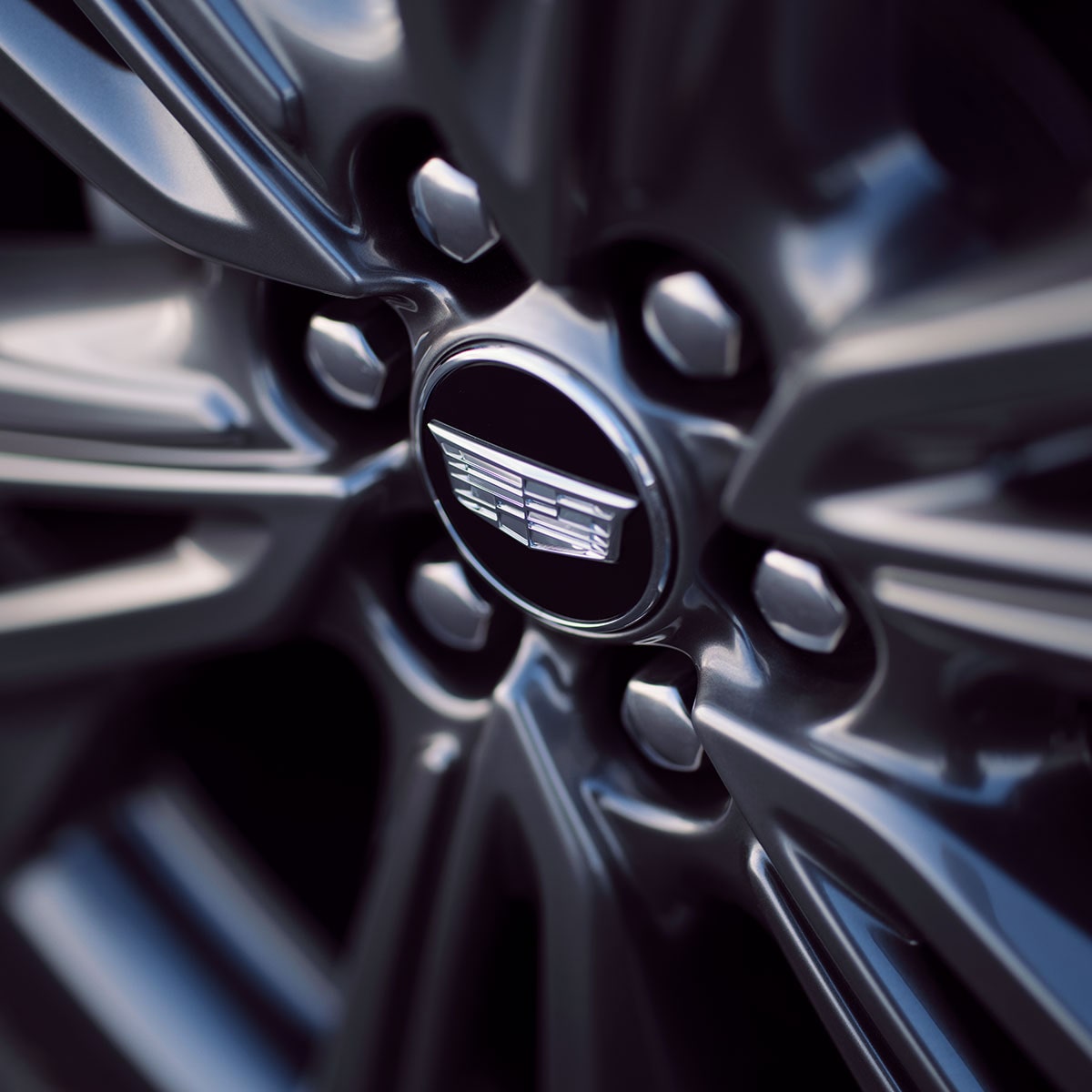 Vue rapprochée du volant OPTIQ 2027 et du logo Cadillac au centre.
