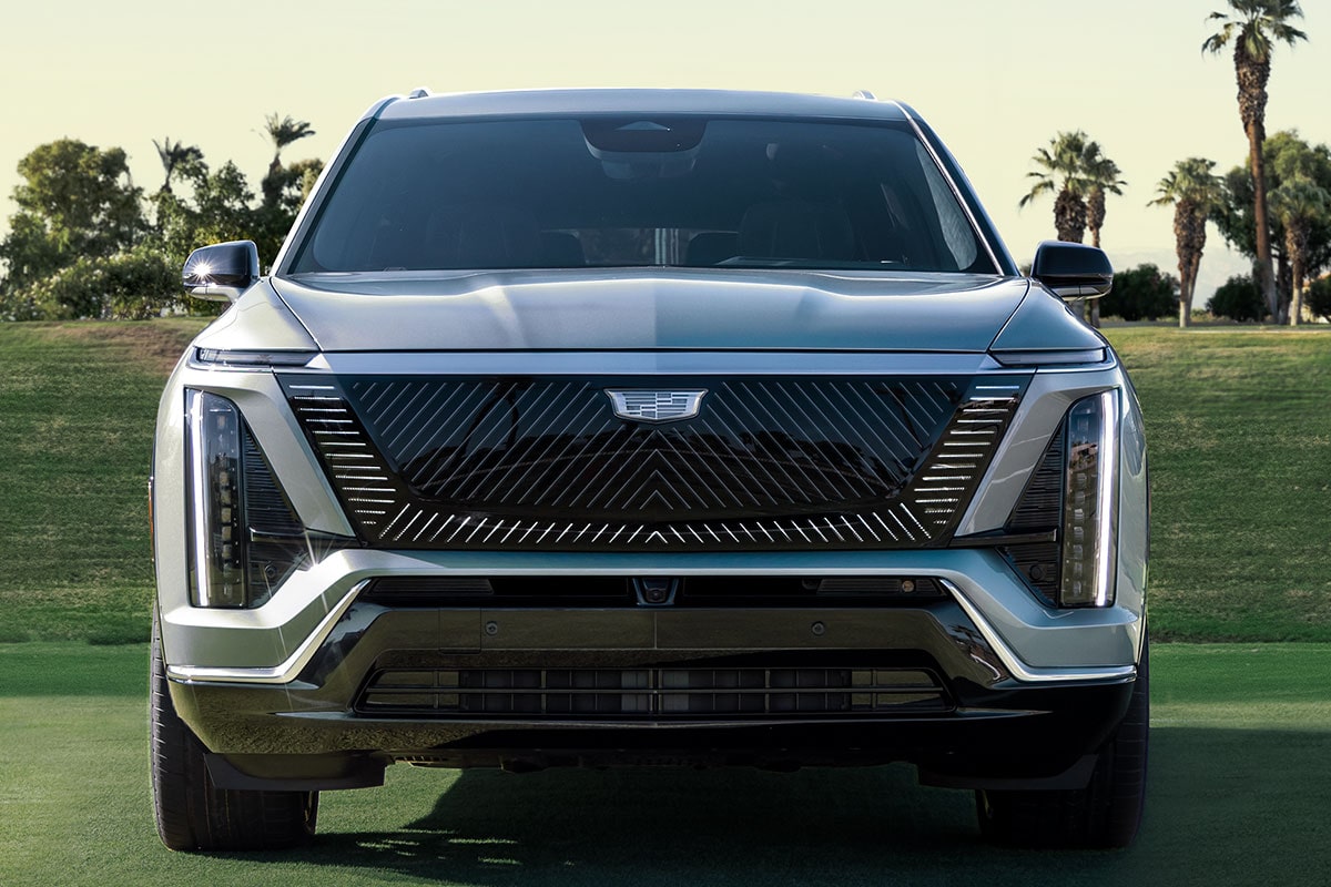 Front View of a 2027 VISTIQ 3-row Electric SUV Parked in a Grassy Tennis Court.