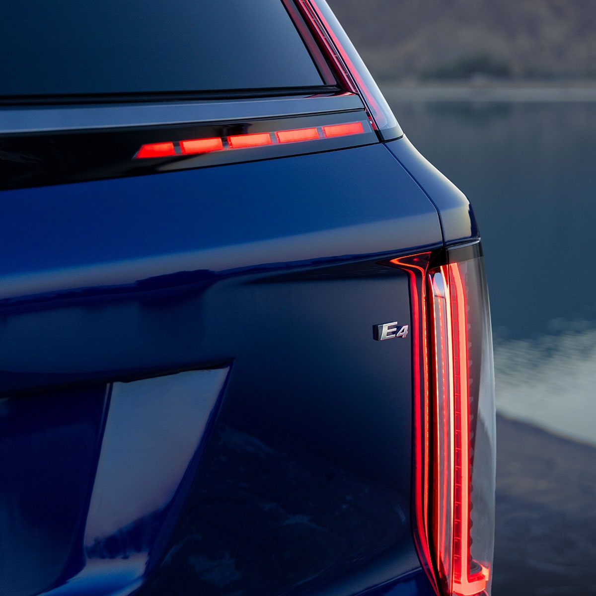 Gros plan d’une Cadillac VISTIQ bleue 2027 montrant le feu arrière et l’écusson E4.