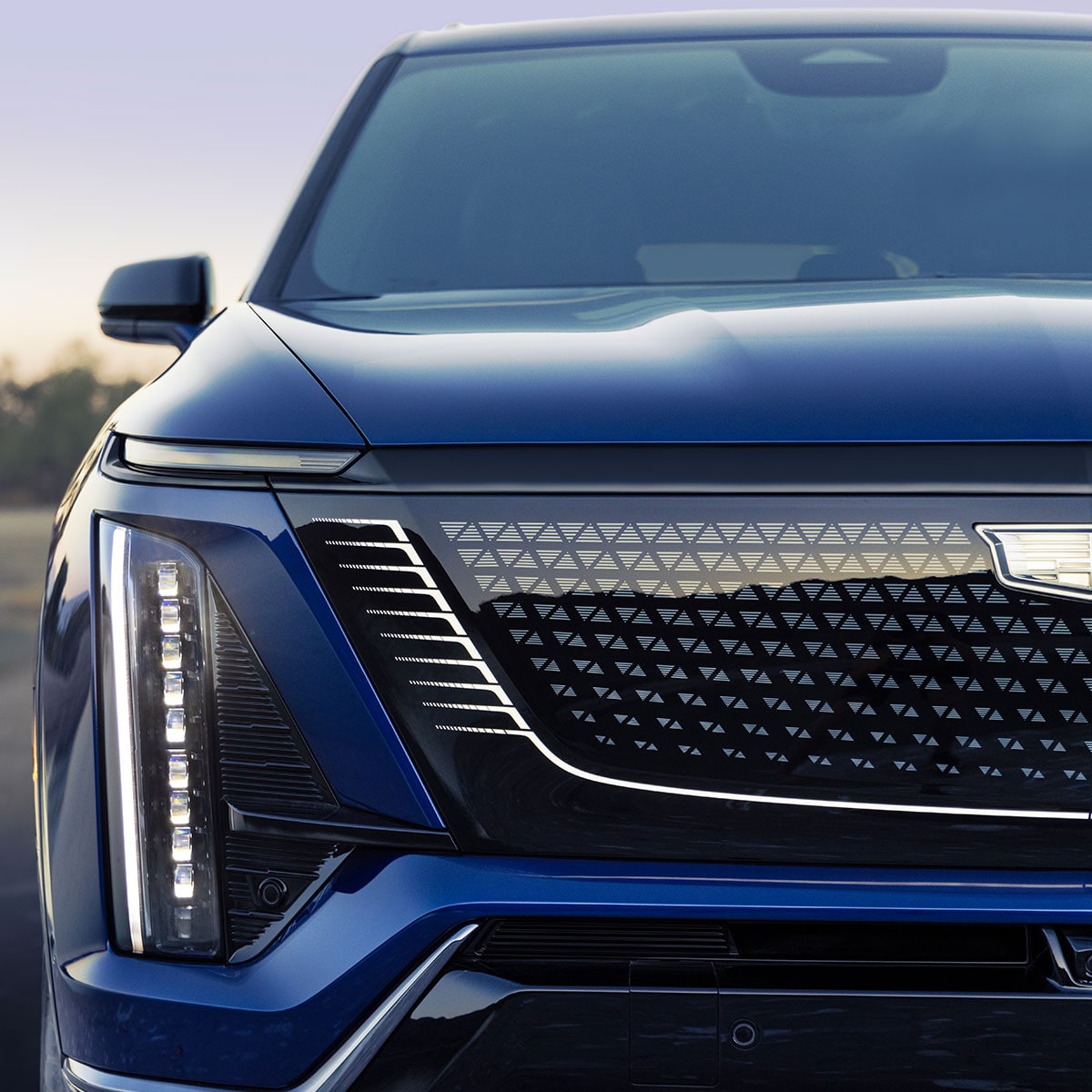 Vue rapprochée de la calandre du SUV VISTIQ 3 rangées 2027 et du phare côté passager.