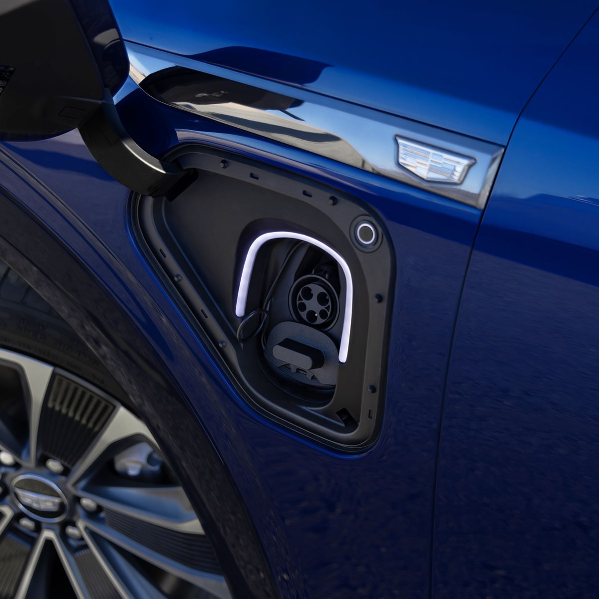 Gros plan de quelqu’un insérant le chargeur de véhicule électrique dans le port de recharge d’un VISTIQ 2027.