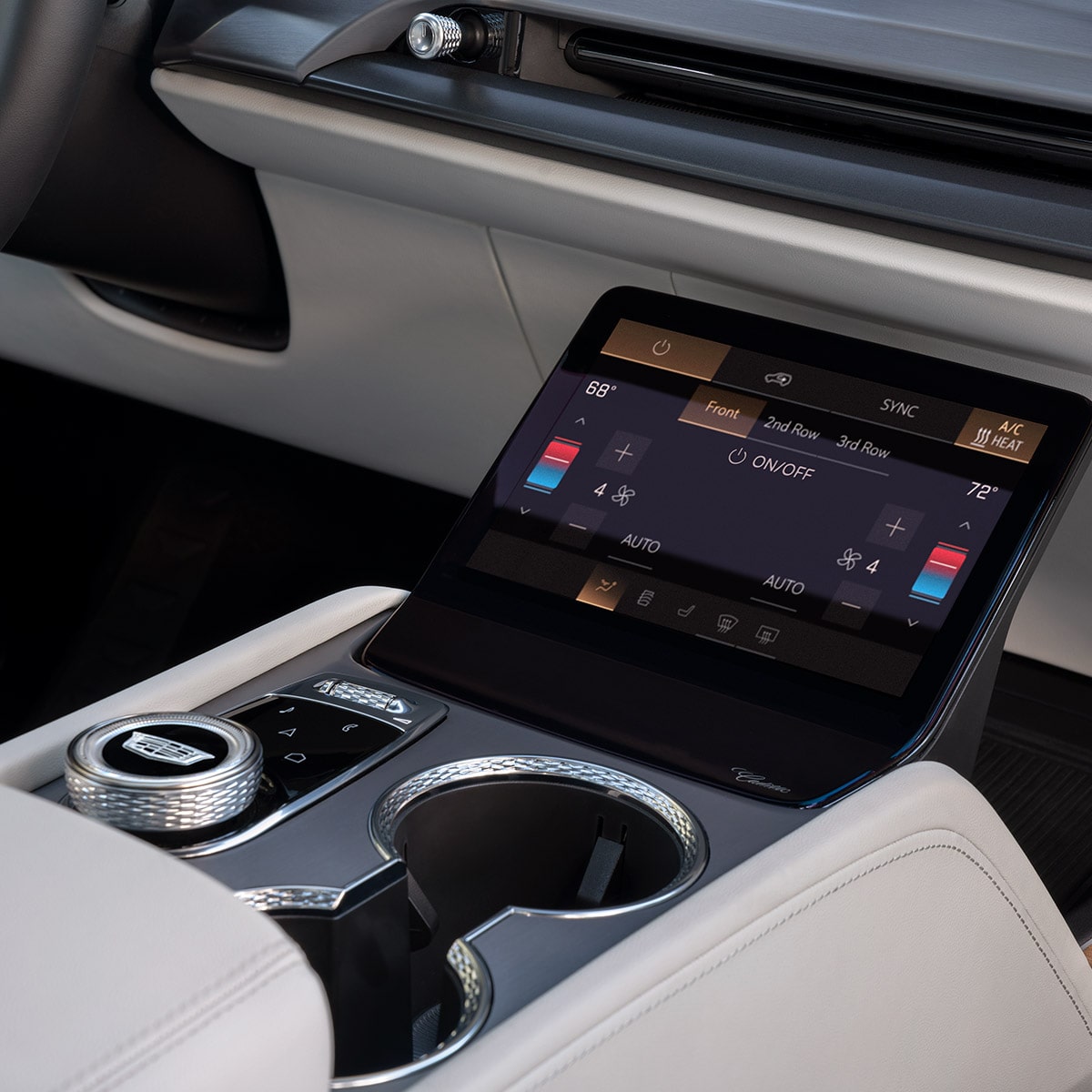 Gros plan sur la console centrale d’une Cadillac VISTIQ 2027 avec porte-gobelets et écran de climatisation.