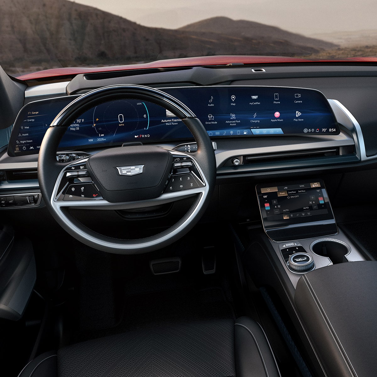 Une vue panoramique à l’intérieur de la première rangée et du tableau de bord d’une Cadillac VISTIQ donnant sur les montagnes.