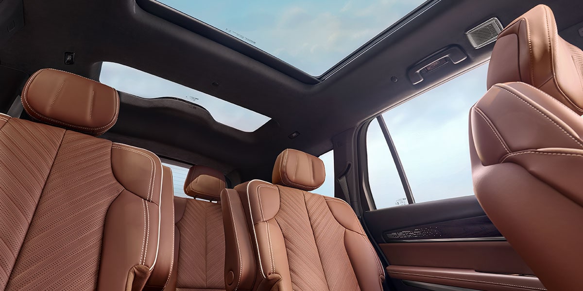 Floorboard View of the 2027 Cadillac VISTIQ's Two Brown Leather Back Rows and Dual Pane Sunroof.