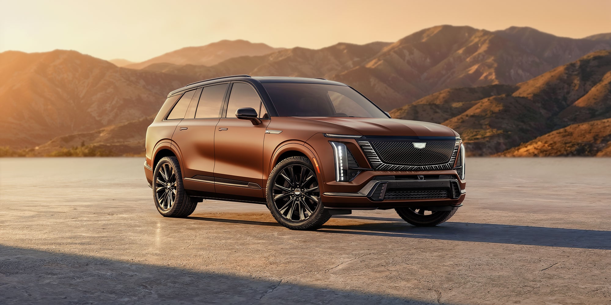 Three-quarter Side View of the 2027 Cadillac VISTIQ Parked Outlooking the Mountains During a Sunset.