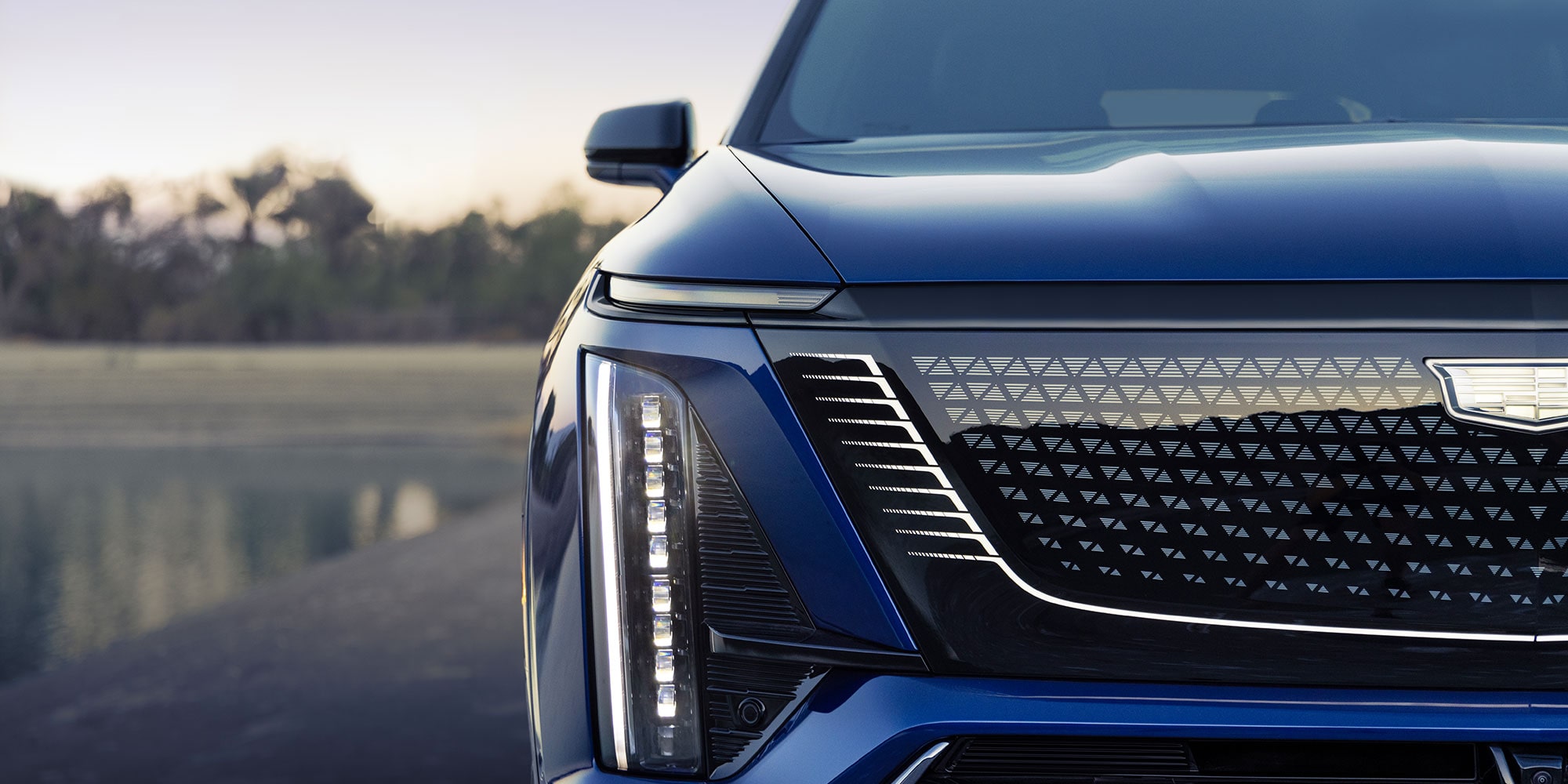 Close-up of the 2027 Cadillac VISTIQ 3-row SUV Grille and Passenger Side Headlamp.