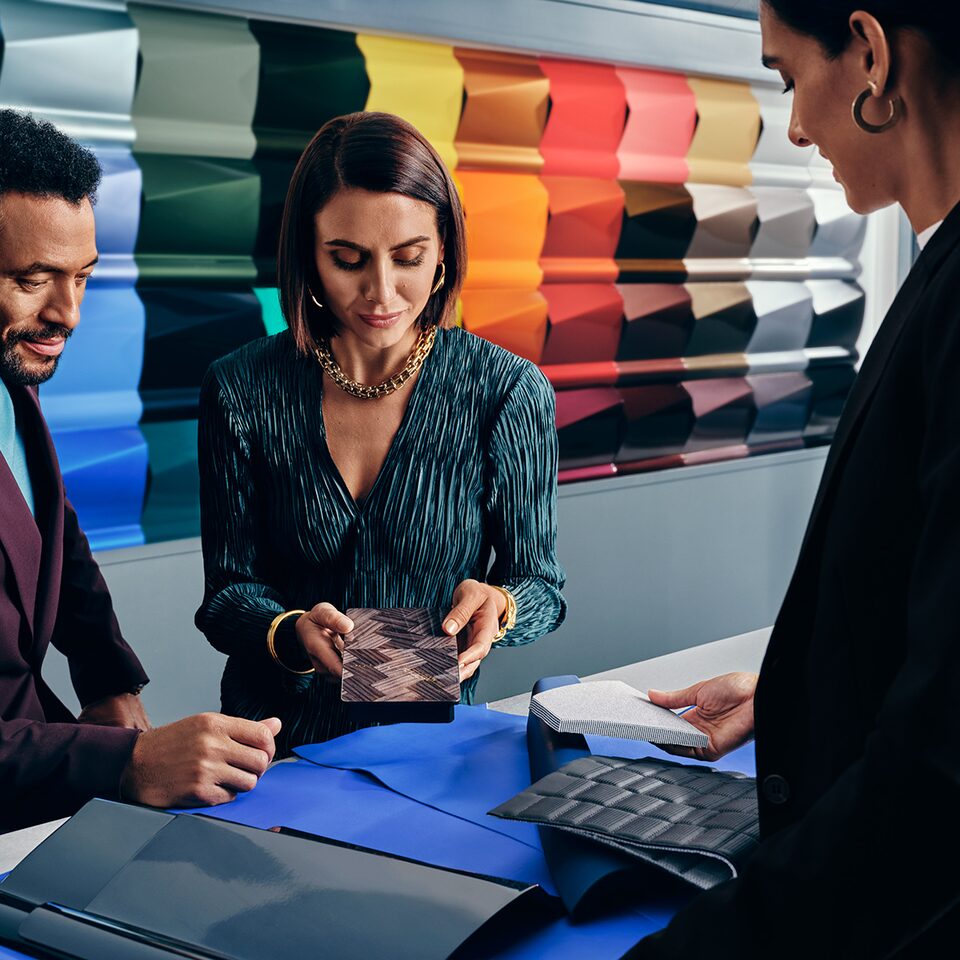 A Cadillac CELESTIQ customer and sales representative discussing colour palettes of the vehicle.