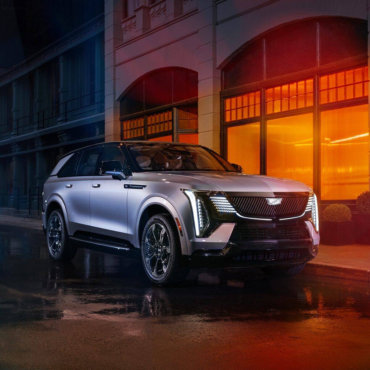 Le Cadillac Escalade IQ stationné devant un bâtiment très éclairé.