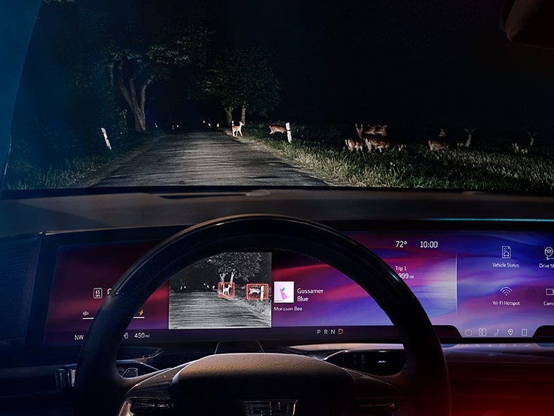 Le Cadillac Escalade IQ en mouvement la nuit avec la fonction de vision nocturne infrarouge activée.