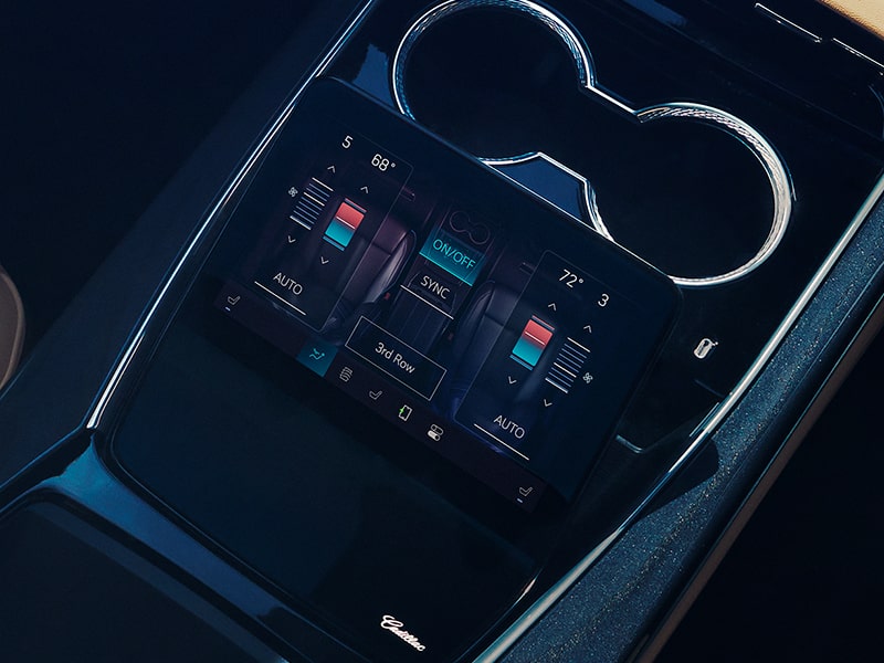 Une personne assise à la deuxième rangée du Cadillac Escalade IQ utilise un écran tactile.