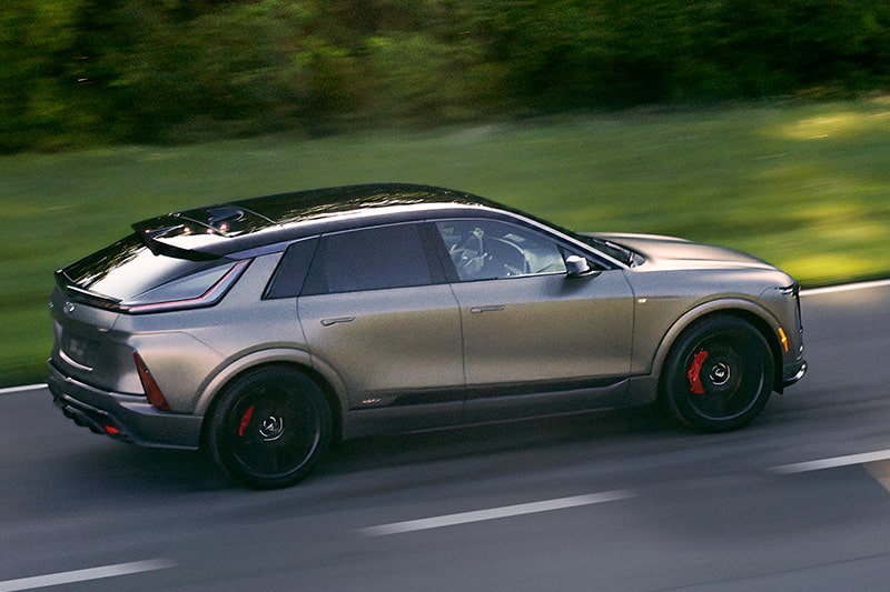A Cadillac SUV covered by a GM Protection Plan driving on the road.