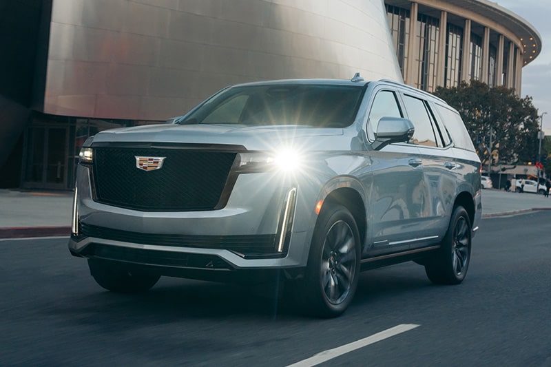A Cadillac SUV covered by a GM Protection Plan driving in a city.