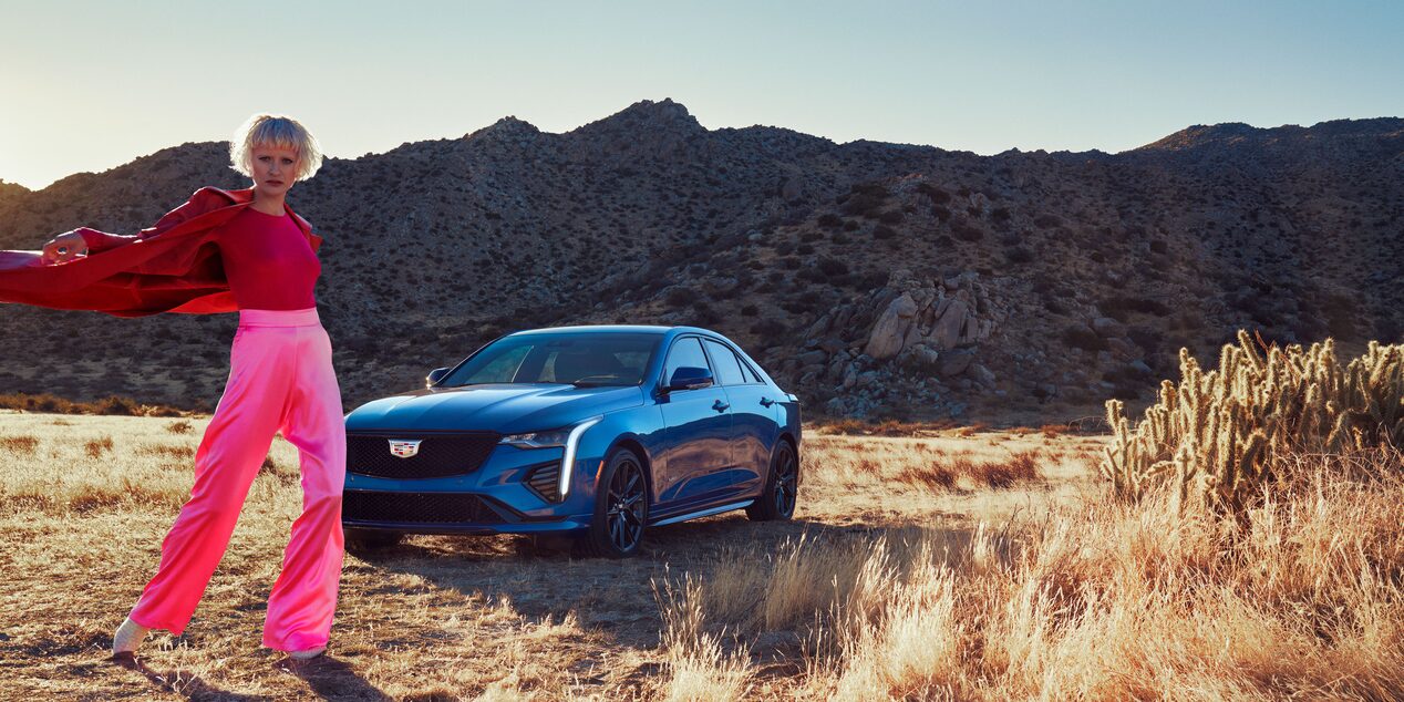 Scenic image of a person posing in front of the 2023 CT4-V.