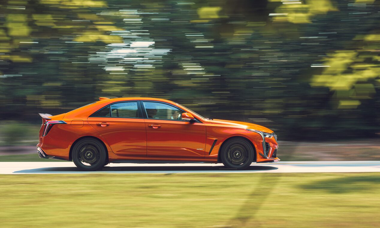 Right profile view of the 2023 CT4-V driving on a road.
