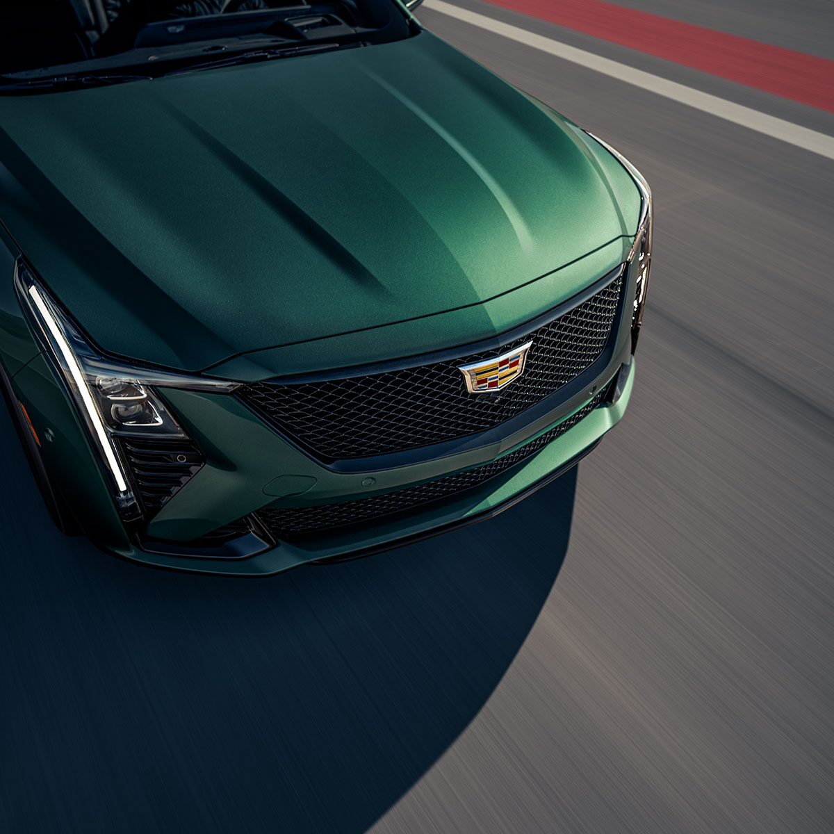 Vue rapprochée du capot d’une Cadillac CT5-V 2025 en mouvement sur la route.