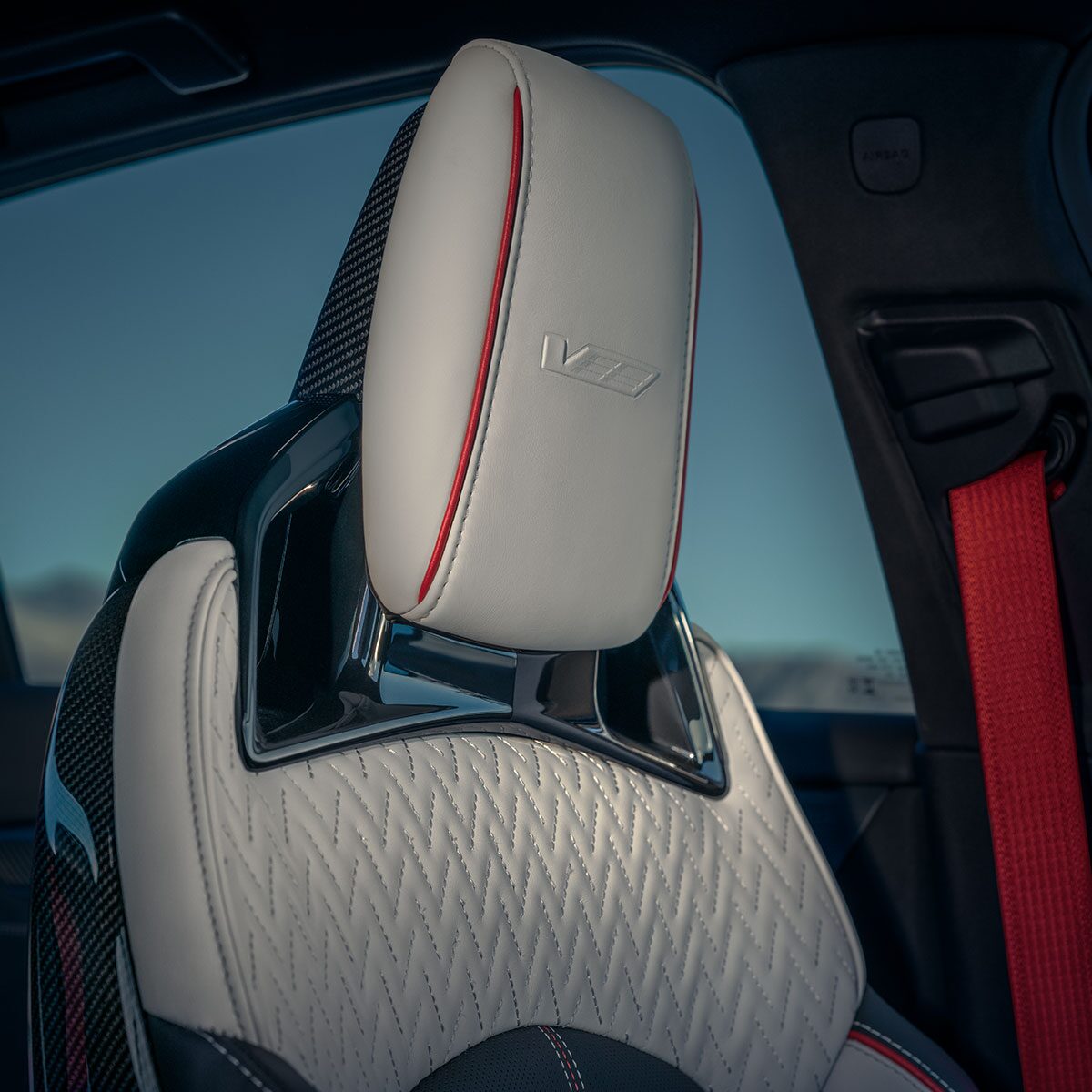 Vue rapprochée des sièges avec ceinture de sécurité rouge de la Cadillac CT5-V 2025.