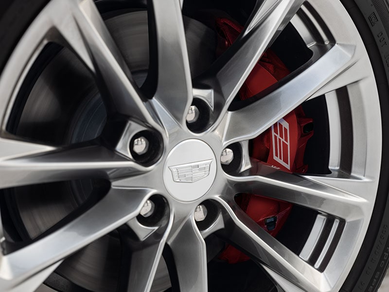 Vue rapprochée des freins Brembo derrière une roue de la berline de luxe Cadillac CT4 2026.