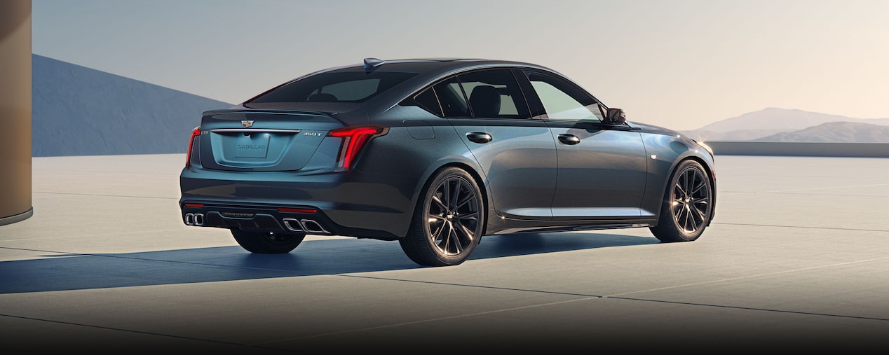 Vue arrière extérieure d'une Cadillac CT5 Sport Sedan 2026 stationnée, avec le ciel bleu en arrière-plan.