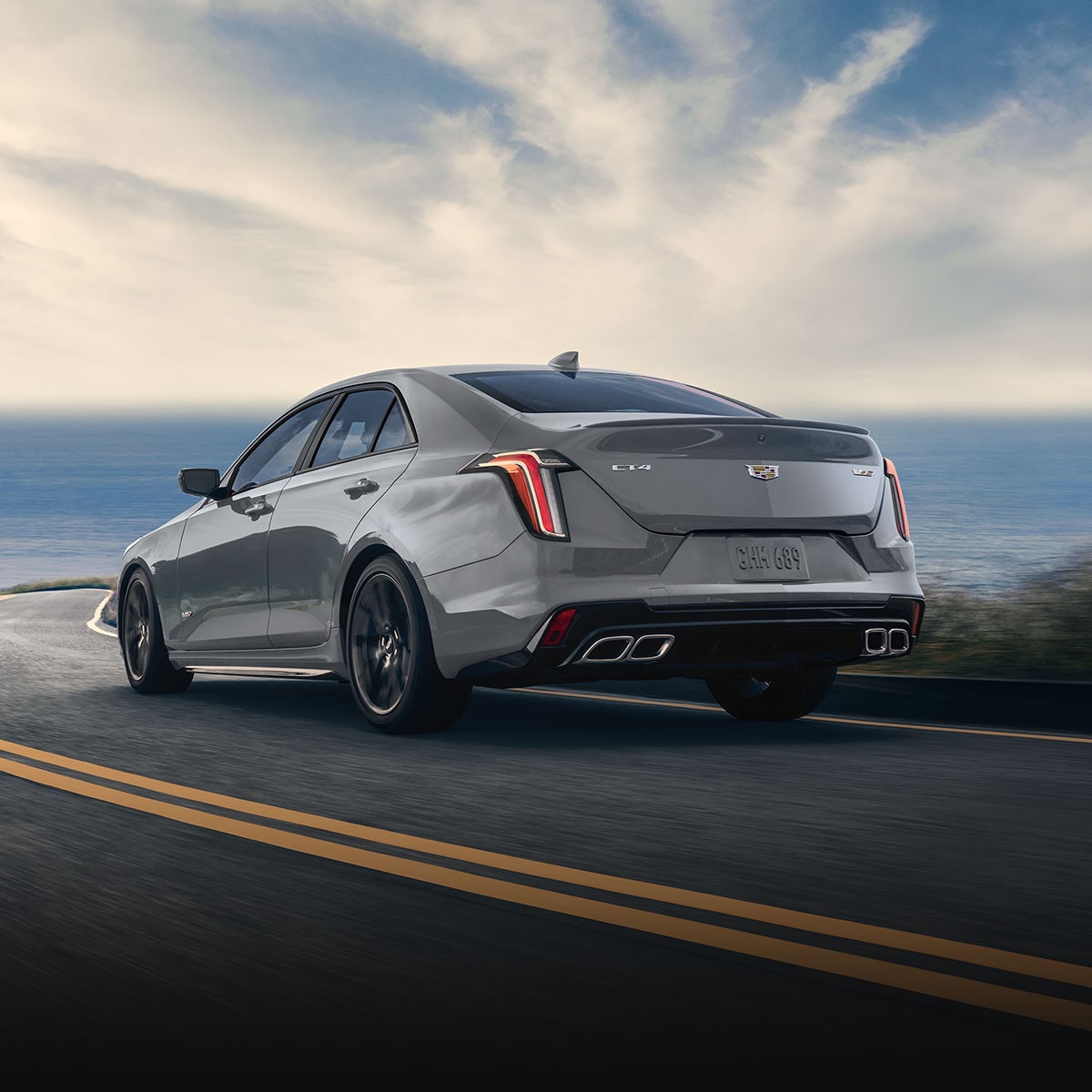 Rear three-quarter view of a Cadillac CT4-V driving alone on the road.