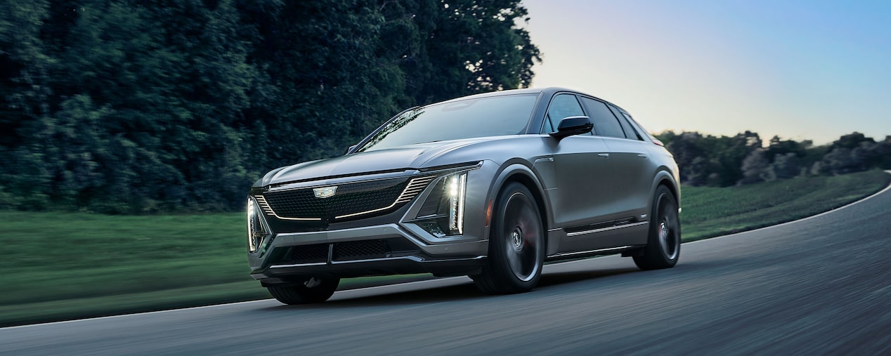 Front-side view of a Cadillac LYRIQ-V driving alone on the road.