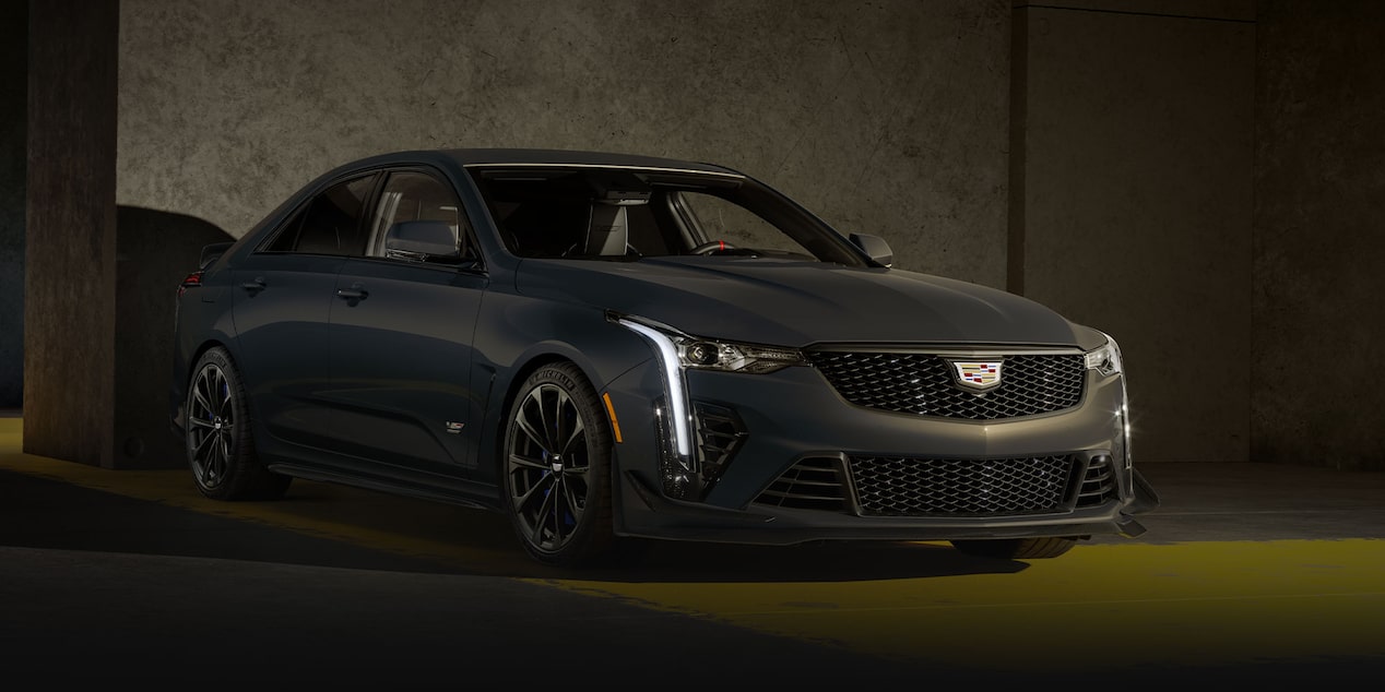 Front three-quarter view of a Cadillac CT5-V Blackwing parked in a dimly lit area.