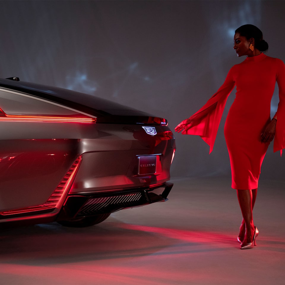 View of a woman standing by the rear of the Cadillac CELESTIQ.