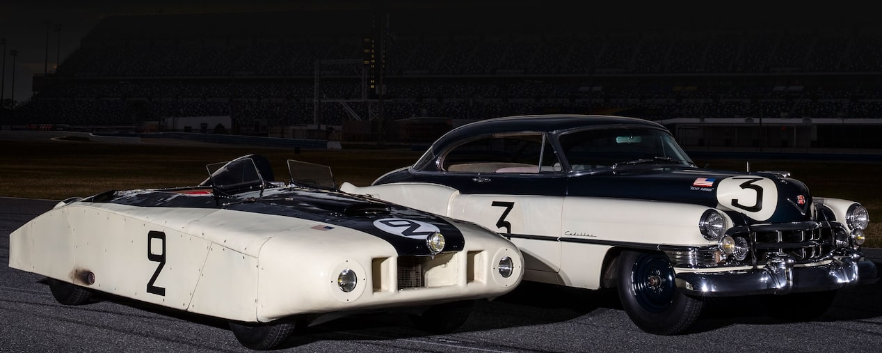 Deux anciennes voitures de course Cadillac stationnées l’une à côté de l’autre.