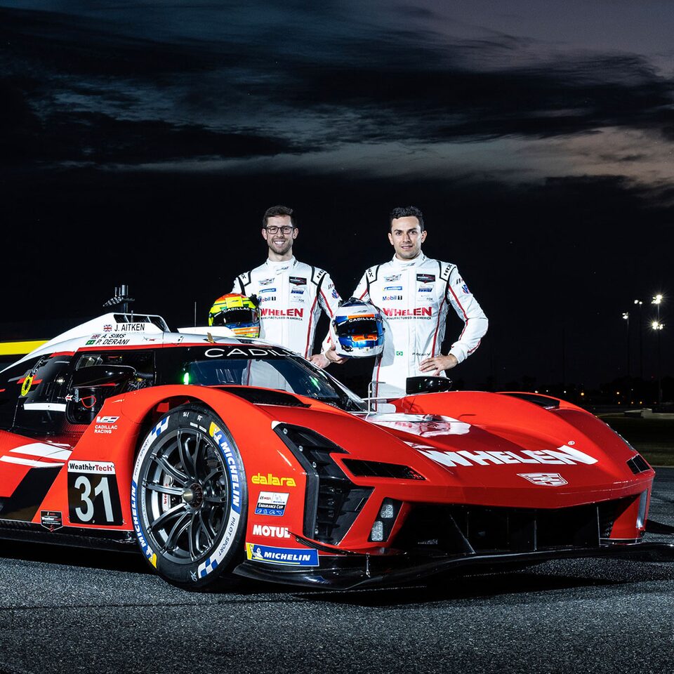 Deux coureurs automobiles à côté de la voiture de course V-Series.R.