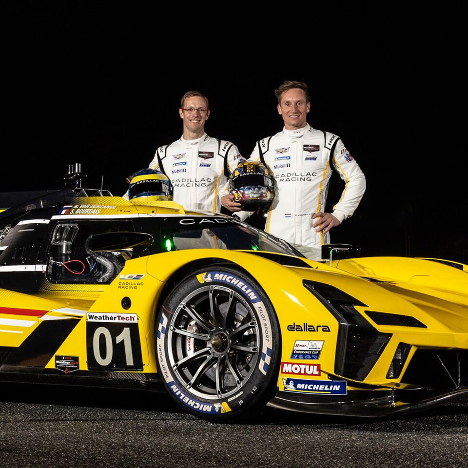 Deux coureurs automobiles à côté de la voiture de course électrifiée V-Series.R.