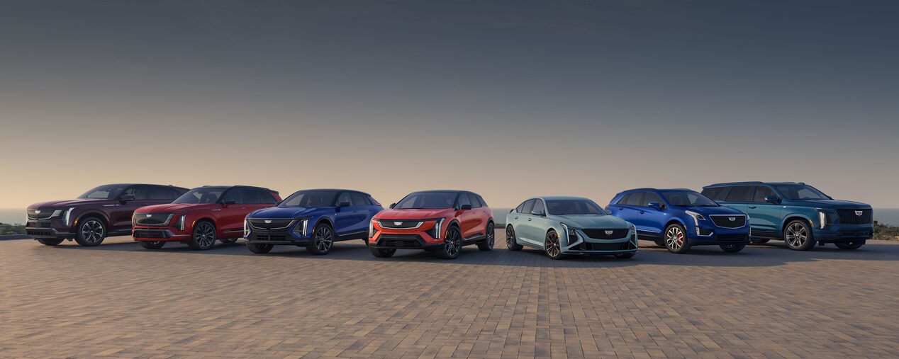 Three Cadillac Silver SUVs Parked on an Open Plain at Sunrise with  Mountains in the Background
