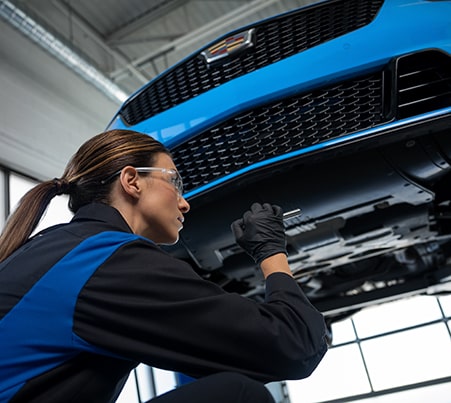 Cadillac Certified Service Technician Replacing Windshield Wipers on a Vehicle