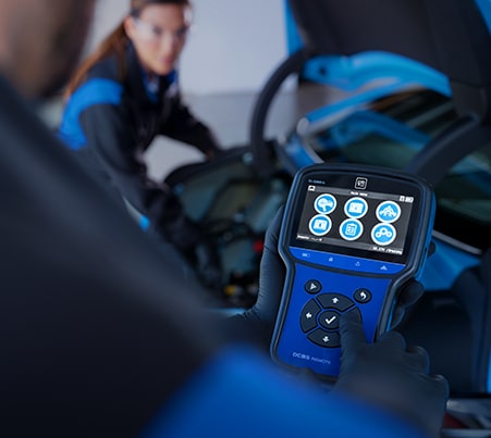 Cadillac Certified Service Technician Using a Performance Diagnostics Tool on a Vehicle