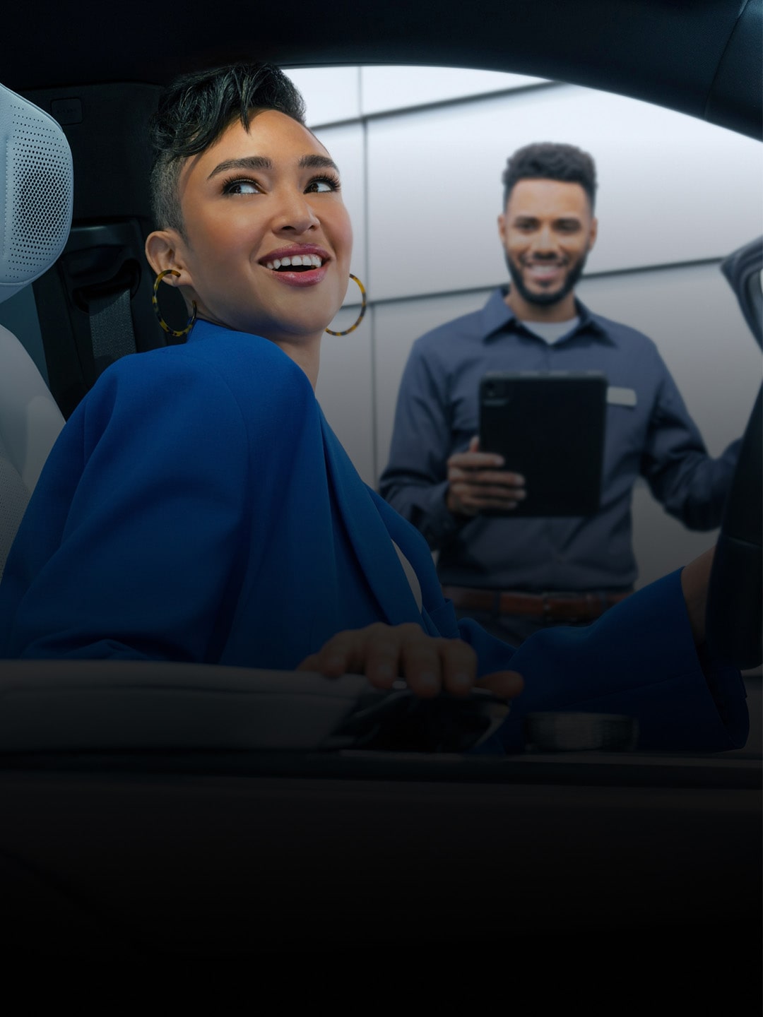 A Certified Service Technican Holding the Door Open for a Female Customer Looking Over Her Right Shoulder and Smiling