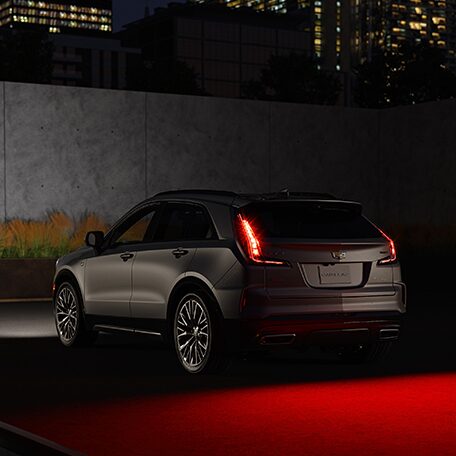 Three Quarters Rear View of a Silver Cadillac Vehicle under the Night Sky
