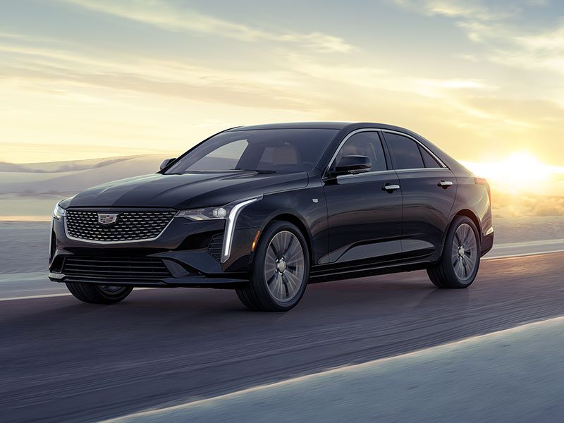 Three-quarters View of a 2026 CT4 Driving Through the Desert During a Sunrise