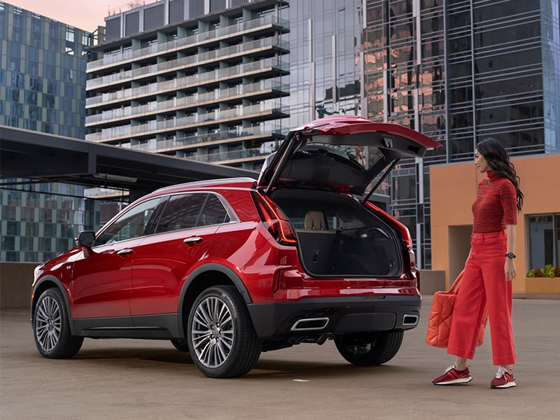 A Woman Wearing All Red Opens the Trunk of Her XT4 To Load Her Bag
