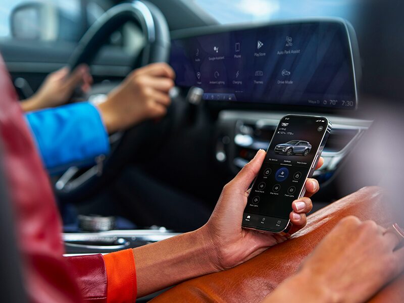 A Passenger Using the OnStar App on an iPhone in a Cadillac