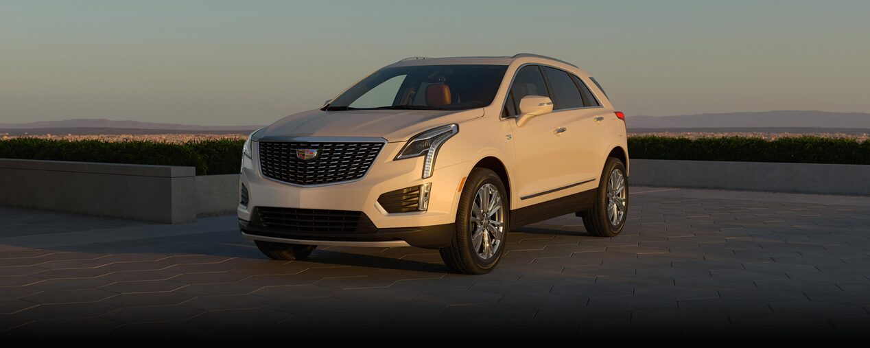 The Sun Setting on a Cadillac XT5 Mid-size SUV Parked in a Concrete Driveway