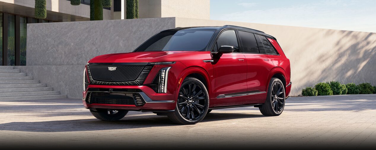 Three-quarter View of a Red VISTIQ Electric SUV Parked near a Concrete Wall