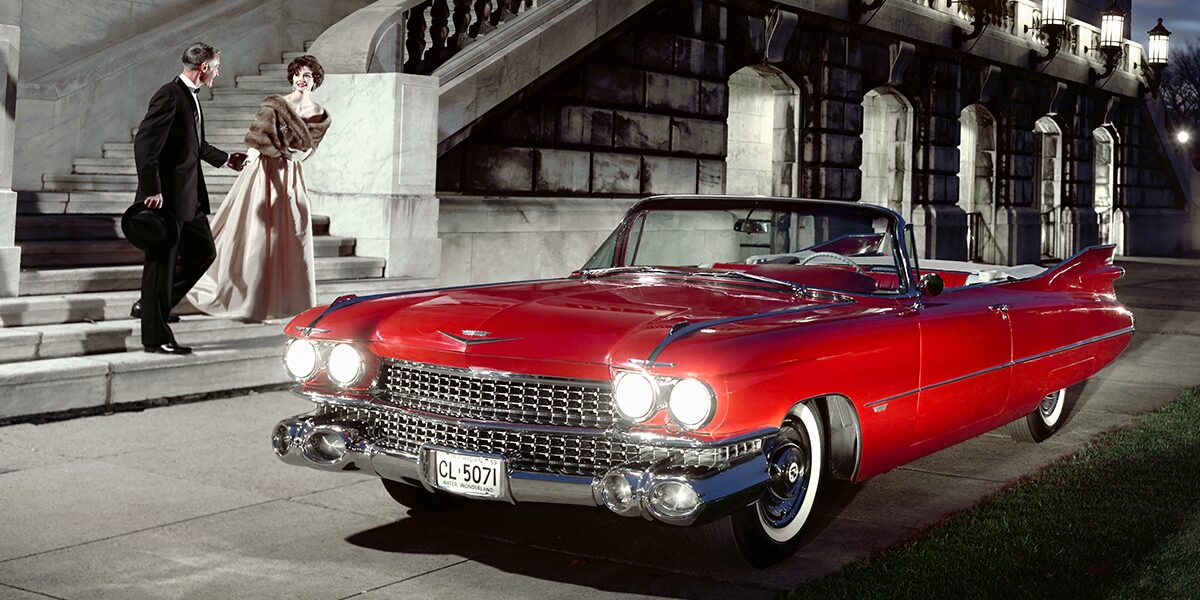A 1950s Couple Walking to a Red Classic Cadillac Convertible