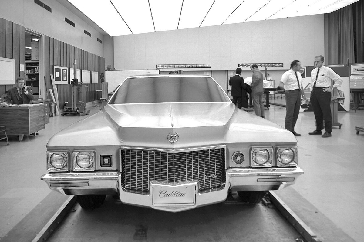 Classic Cadillac In Showroom With Men Standing Around