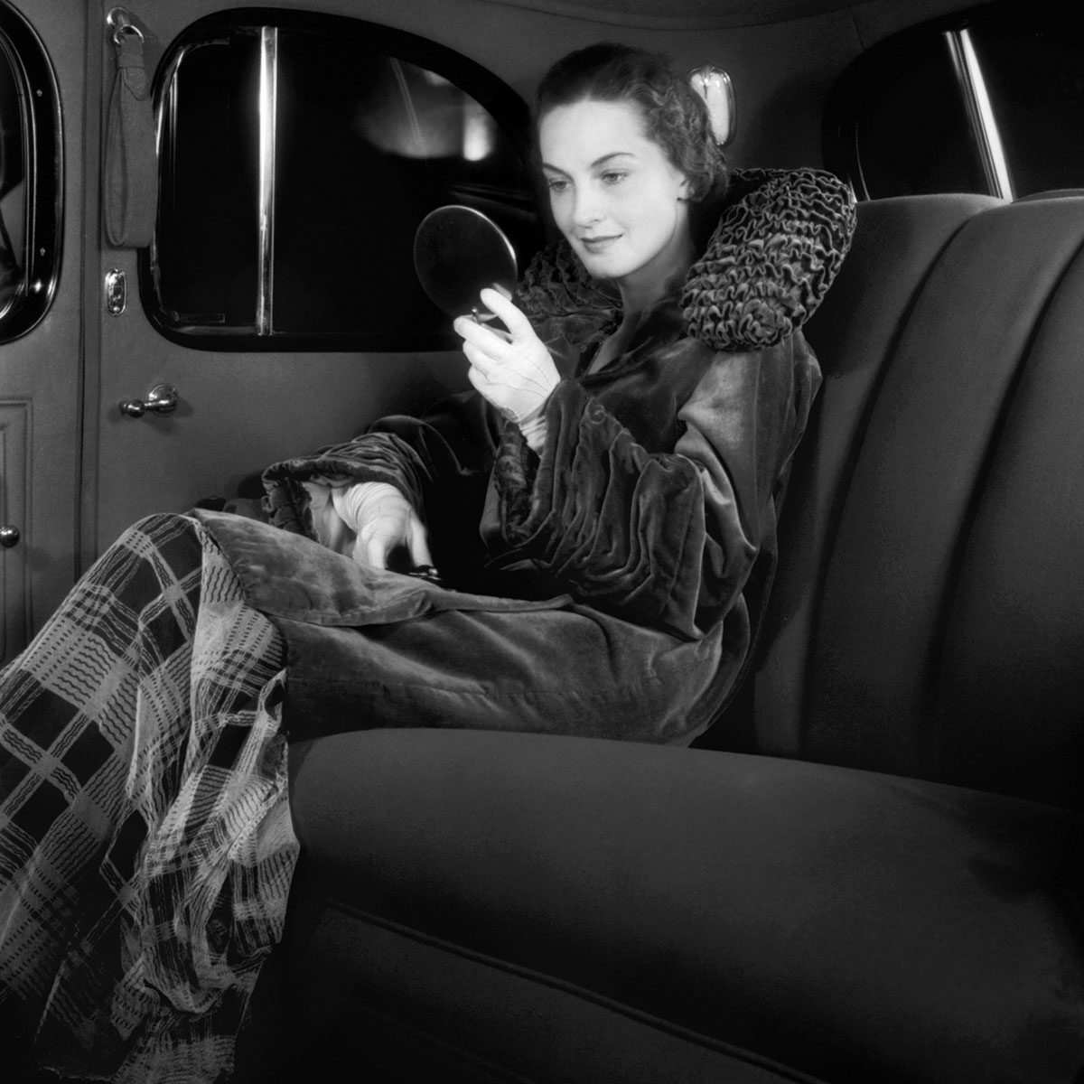 Woman Checking Her Makeup In Rear Seat Of Classic Cadillac