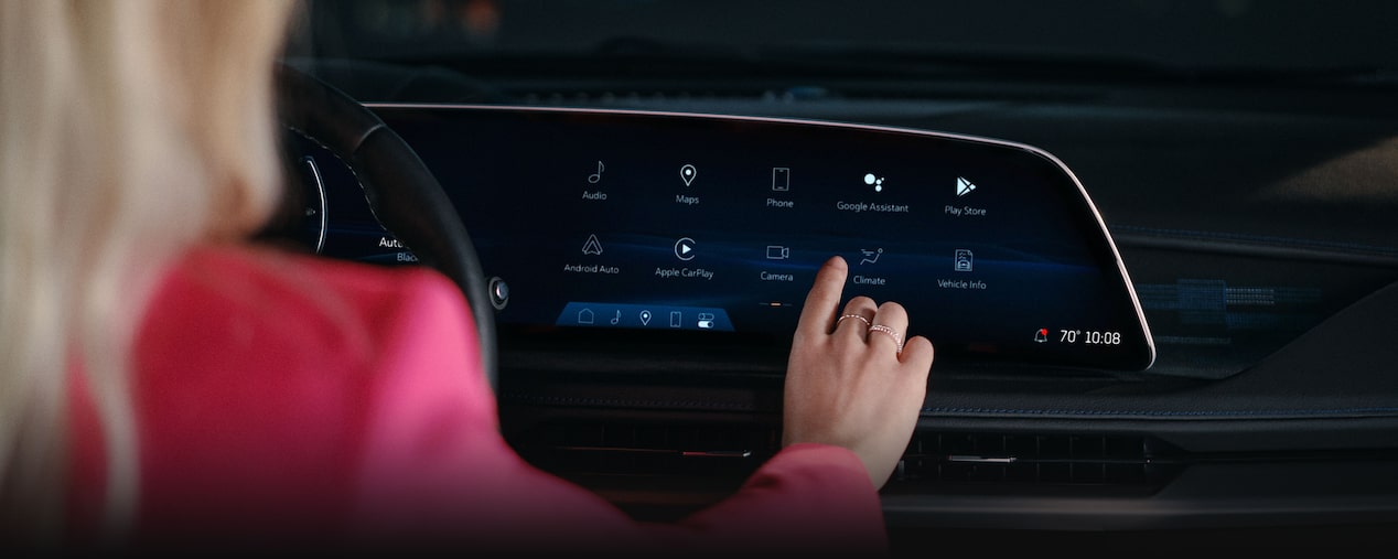 A Woman Utilizing the 2025 Cadillac XT5 Infotainment System Touch Screen
